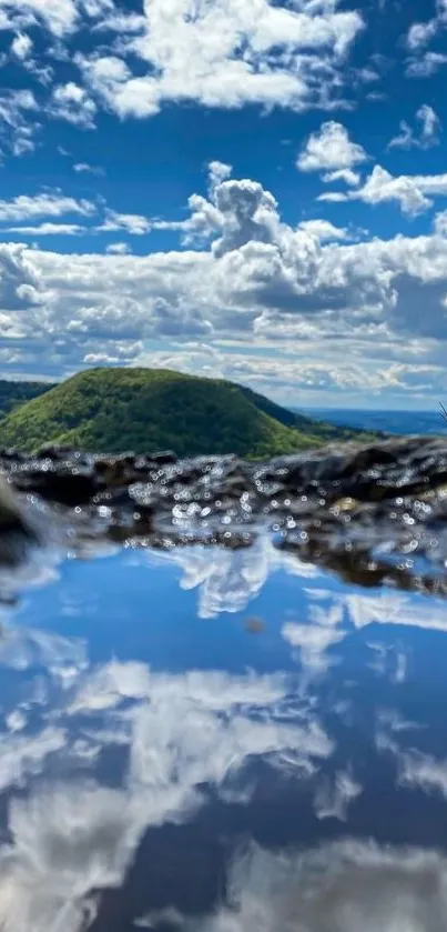 Scenic landscape with blue sky and hills reflection in water.