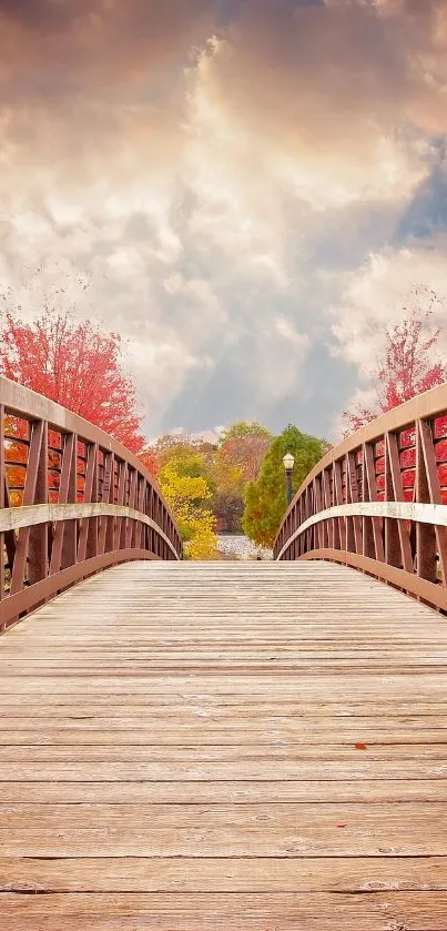 Wooden bridge surrounded by autumn colors under a cloudy sky.