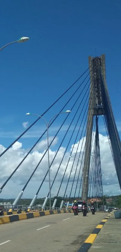 Cable-stayed bridge under vibrant blue sky with clouds.