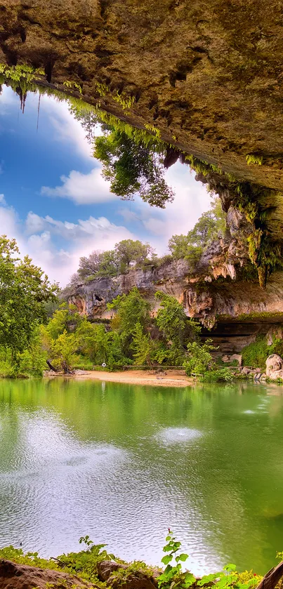 Scenic view of a cave and lake with lush greenery and clear blue sky.