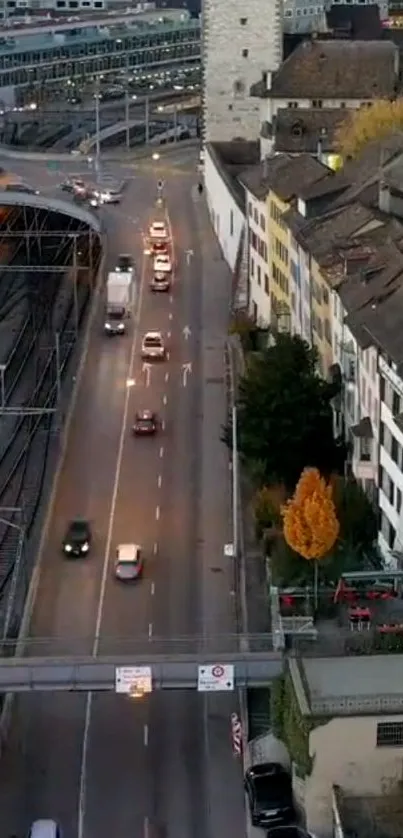 A scenic city street with cars and autumn trees, under a gray sky.