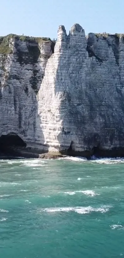 Turquoise sea with striking white cliffs, forming a serene coastal landscape.