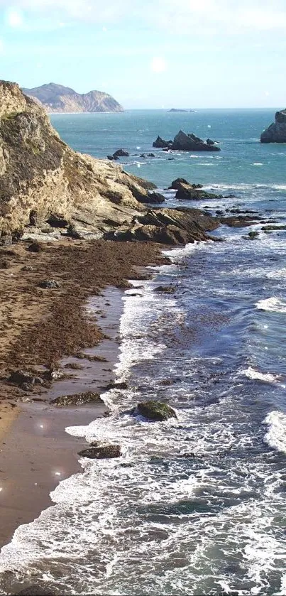 Scenic ocean view with sandy beach and rocky cliffs.