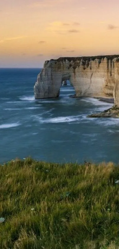 Stunning coastal cliff with sunset over ocean waves.