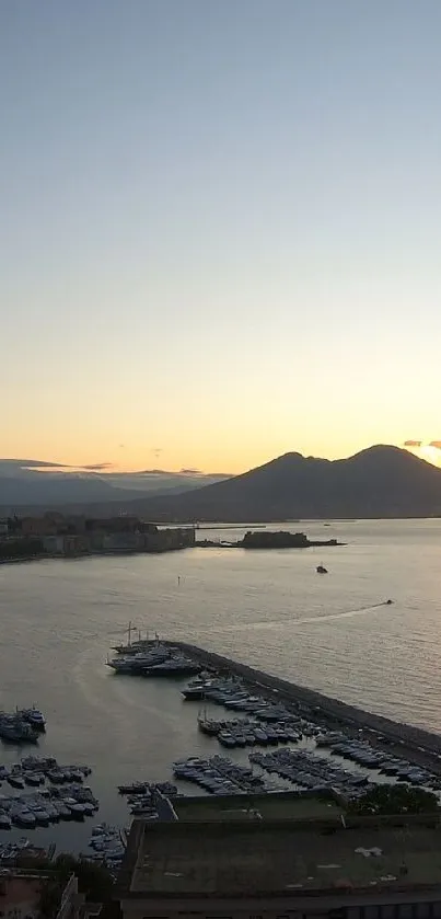 Scenic evening coastal view with mountains and calm sea at sunset.