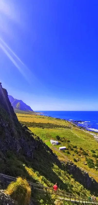 Vibrant coastal mountain scene with blue sky and ocean.