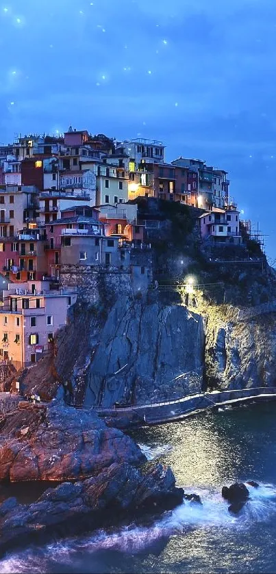 Scenic coastal town at night with blue sea and city lights.