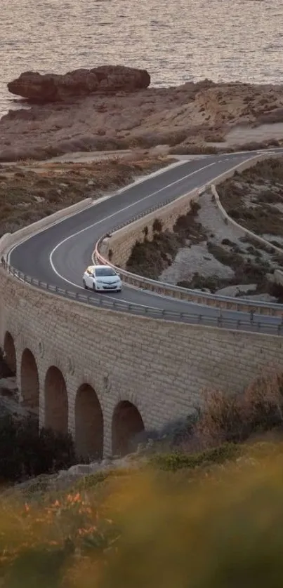 Car driving on scenic coastal road at sunset, perfect mobile wallpaper.