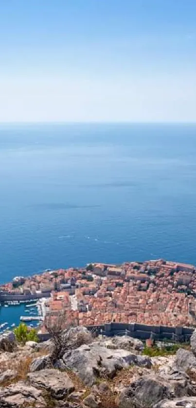 Hiker overlooking scenic coastal view with ocean and historic city.