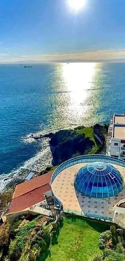 Sunlit coastal view with ocean, buildings, and architecture.