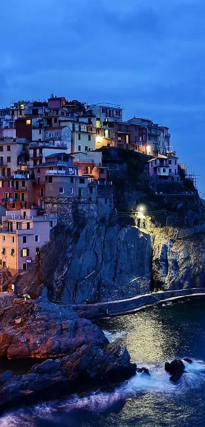 Scenic view of a coastal village at dusk with illuminated houses and sea.