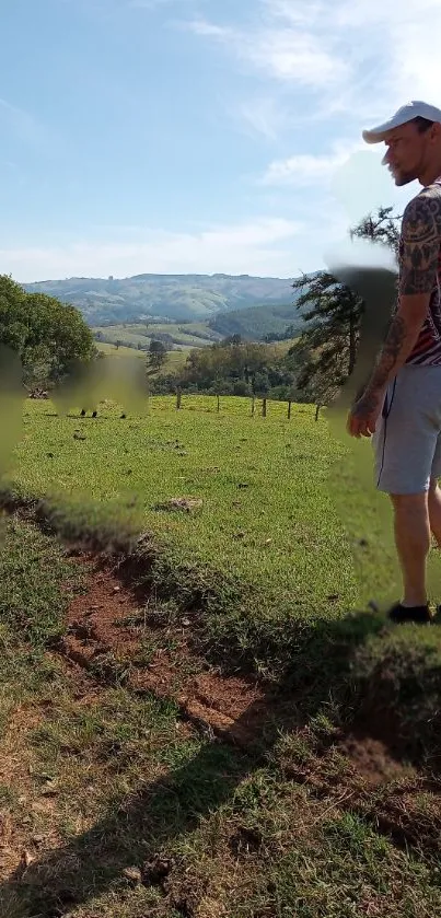 Man walking in a lush green meadow under cloudy skies.