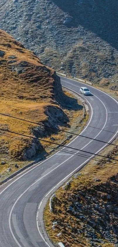 Winding road in mountain landscape with car driving