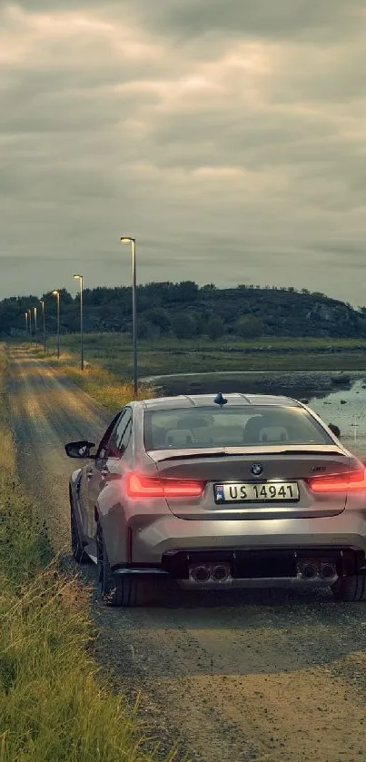 Car on a scenic countryside road at dusk with moody clouds.