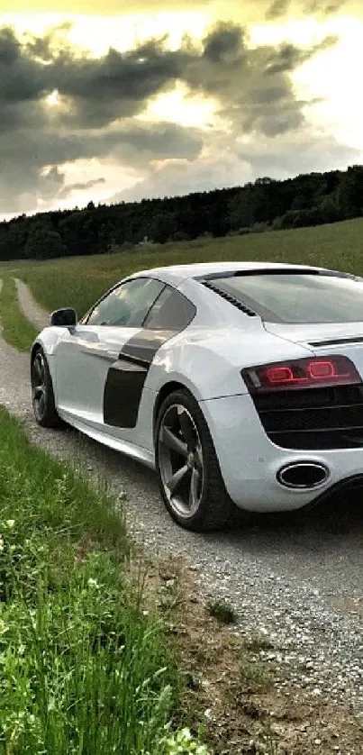 Luxury car driving on a scenic road with green fields and dramatic sky.