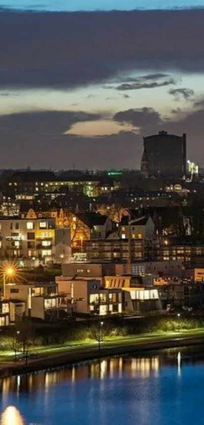 Evening cityscape with lights and a calm river under a twilight sky.