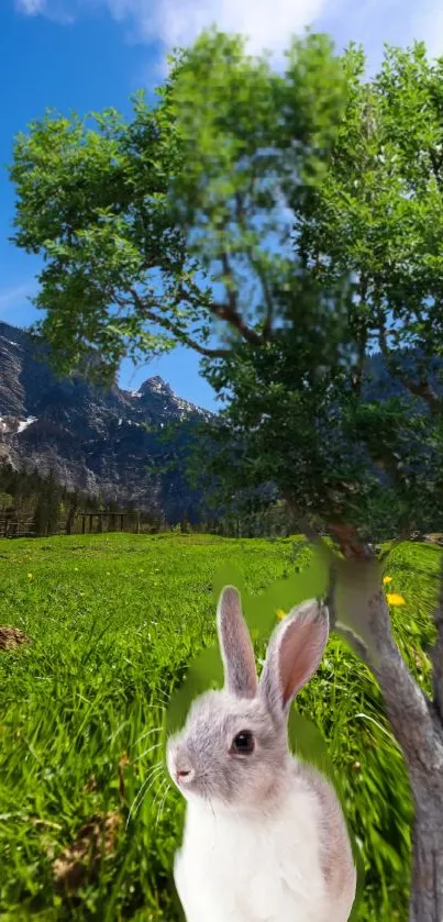 Rabbit under tree in scenic meadow with mountains.