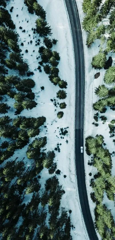 Aerial view of a snowy forest road in winter.