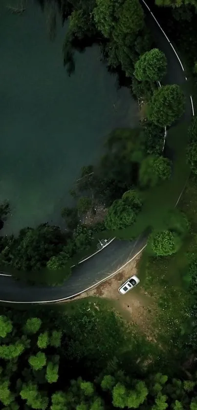 Aerial view of car on scenic forest road by the lake.