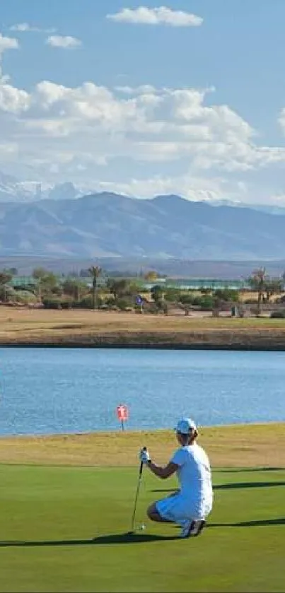 Golfers on a scenic course with mountains and clear sky.