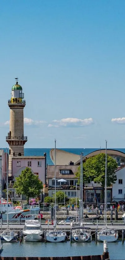 Scenic harbor with lighthouse and boats under a blue sky.