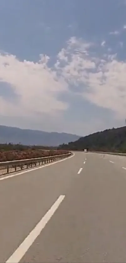 Scenic highway with blue skies and clouds, perfect for travel lovers.