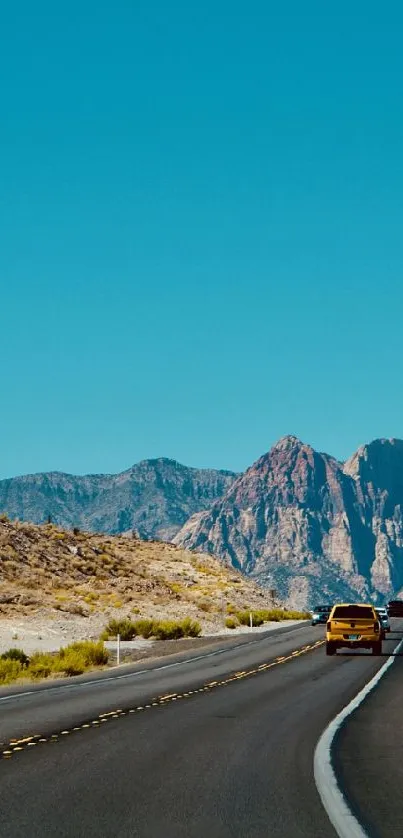 Scenic highway through desert mountains under a clear blue sky.