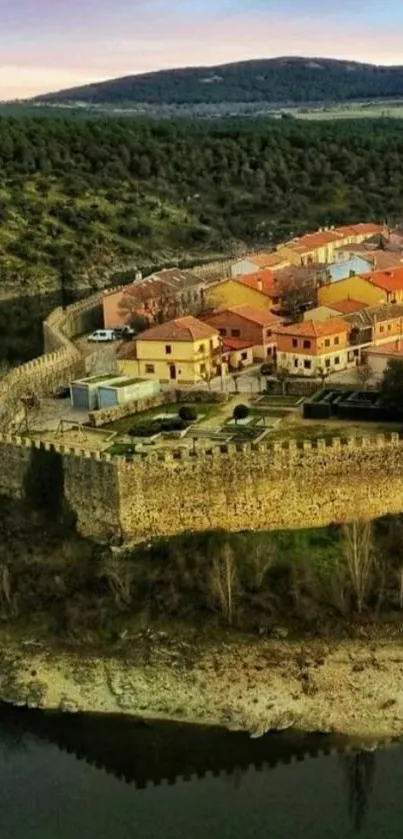 Scenic aerial view of a hilltop castle with surrounding greenery and water.