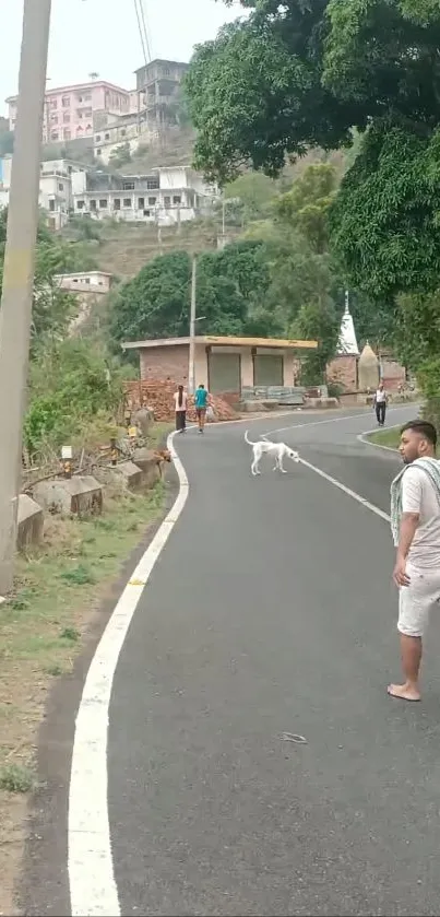 Man walks on scenic hilly road with greenery.