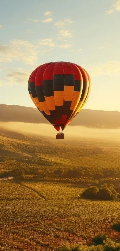 Hot air balloon floating over a scenic sunrise landscape.