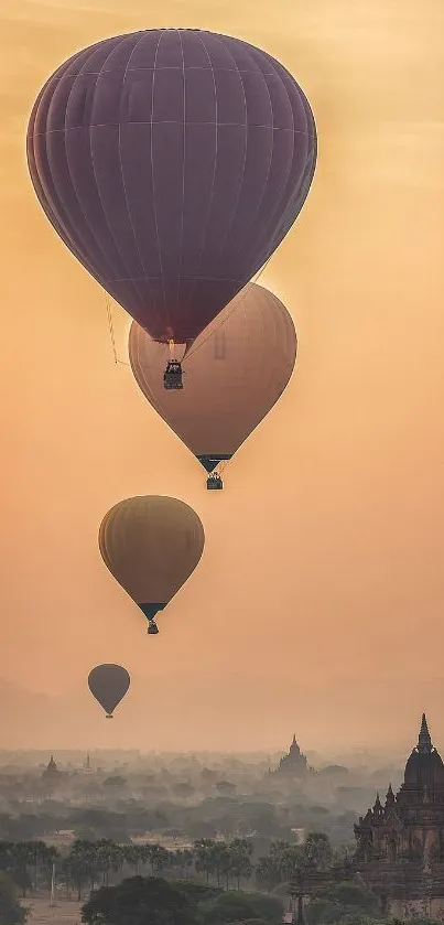 Hot air balloons ascend over an ancient city at sunset.