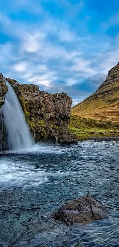Stunning Icelandic waterfall with mountain backdrop under a cloudy sky.
