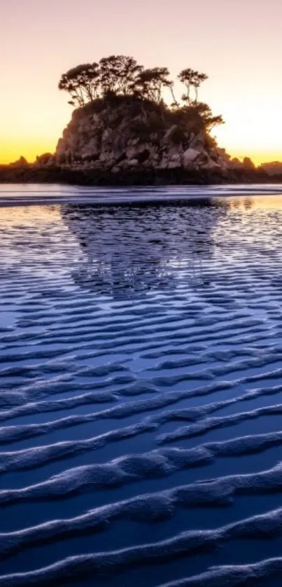 Scenic island and sunset with purple and orange hues reflected on the water.