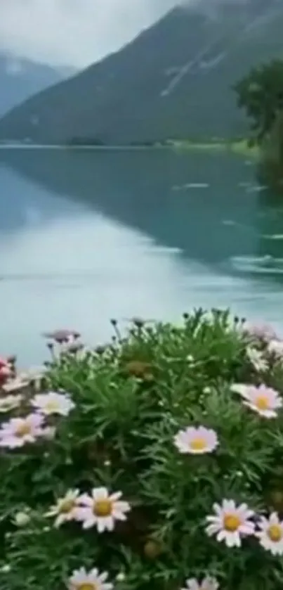 Serene lake with mountains and vibrant flowers in foreground.