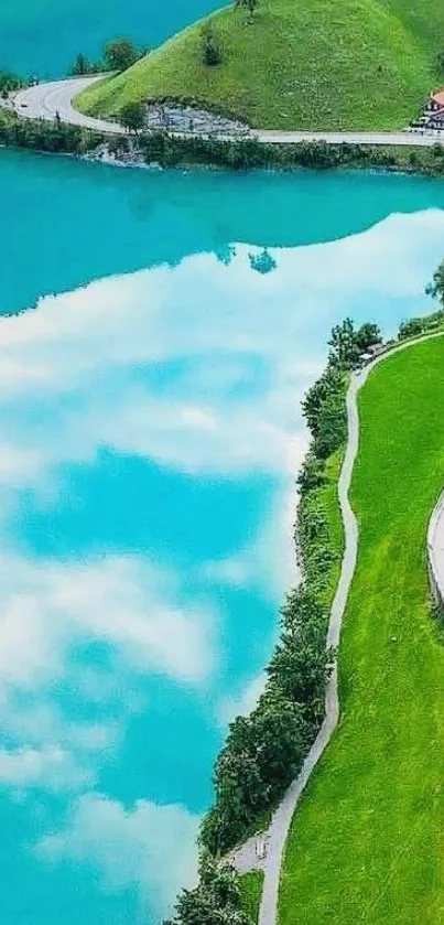 Turquoise lake surrounded by lush green hills and winding road.