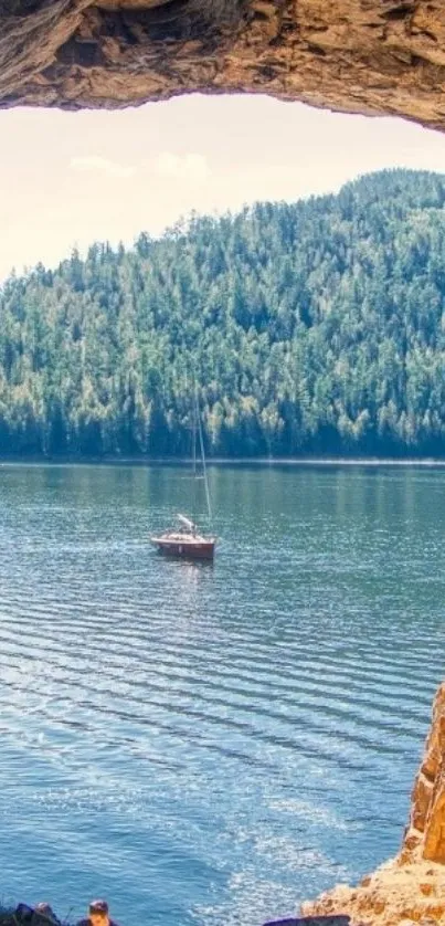 View from a cave overlooking a scenic lake and forest.