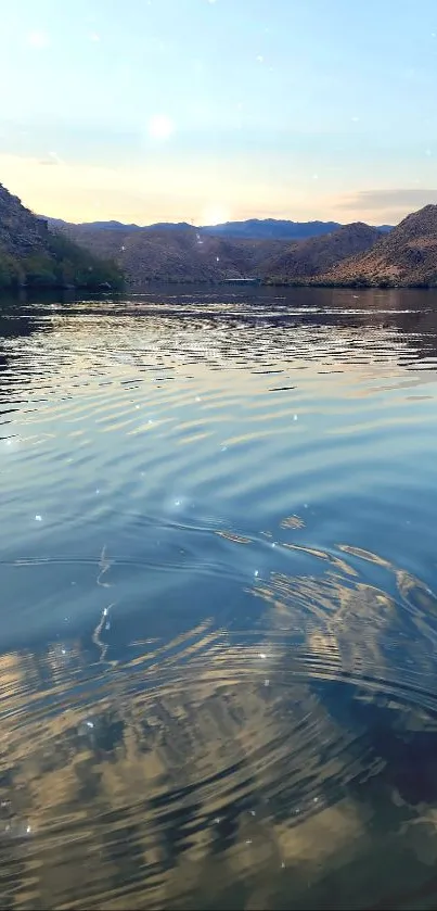 Peaceful lake with mountain reflections under a clear sky.