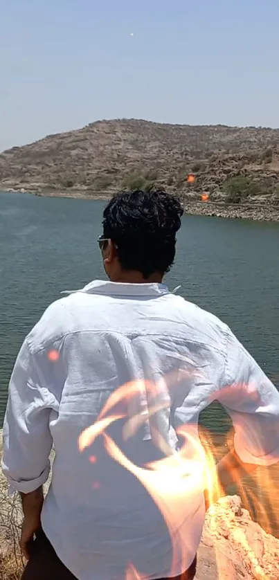 Serene lake with scenic backdrop and man overlooking the view.