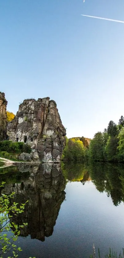 Scenic rock formations reflected in a tranquil lake under a clear blue sky.