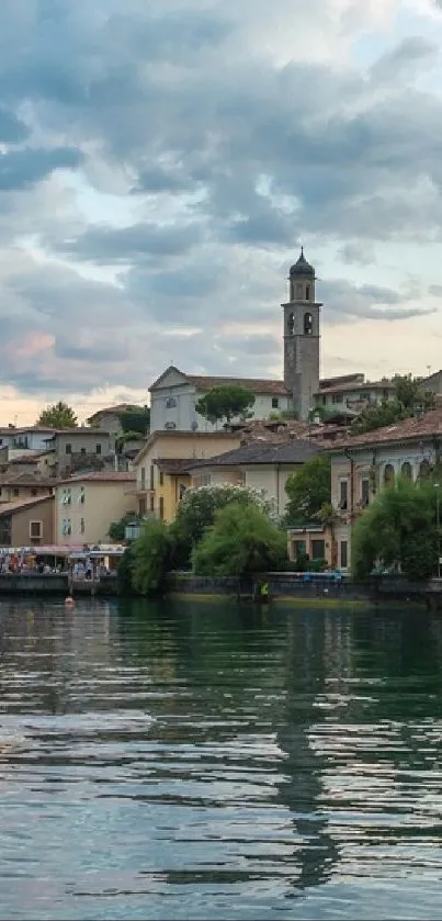 Scenic lakeside village with clock tower at dusk.