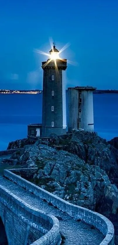 Lighthouse on rocky shore at twilight, calm ocean backdrop.