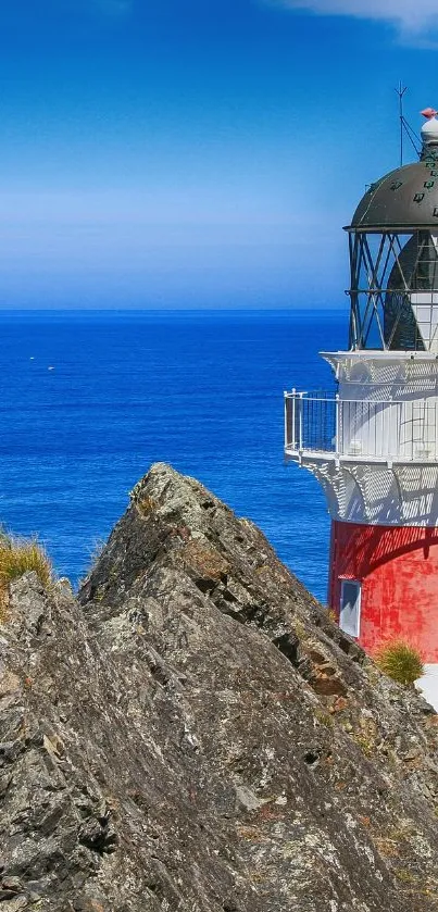 Lighthouse by the blue ocean with clear sky.