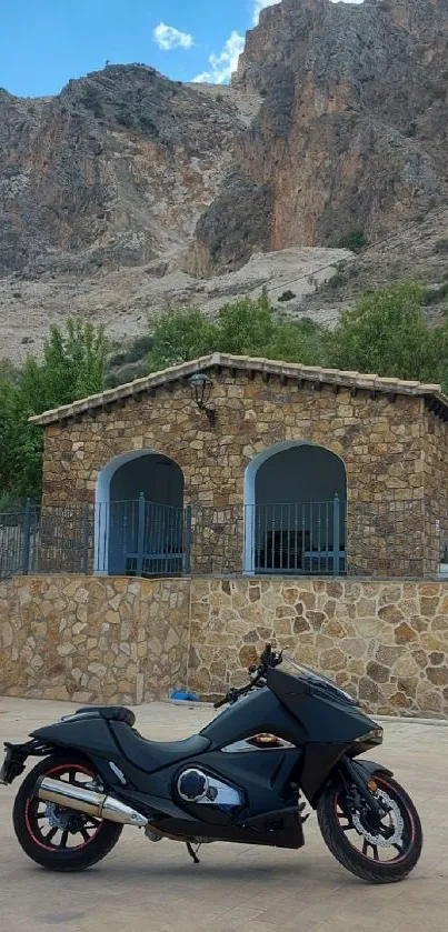 Sleek motorcycle parked by rustic cabin beneath towering cliff.