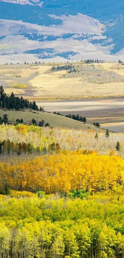 Autumn mountain landscape with yellow trees under blue sky.