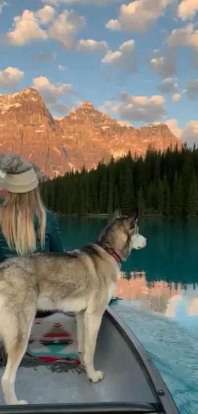 Woman in canoe with dog on a mountain lake at sunset.