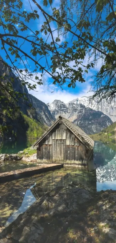 Mountain lake with rustic cabin and blue sky.