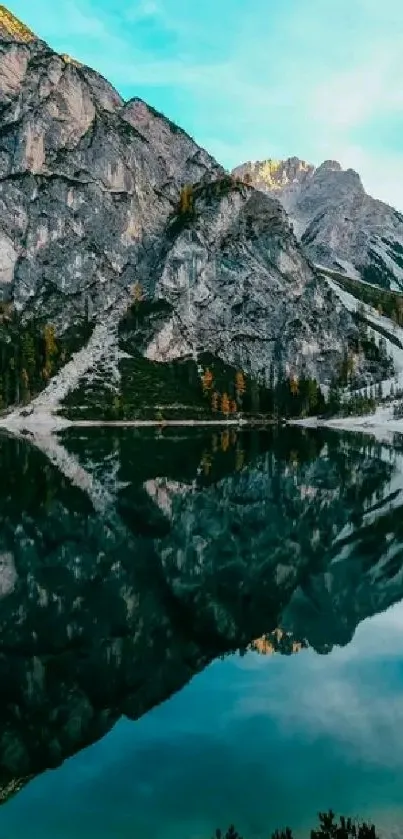 Mountain lake with reflection of autumn trees and blue sky.