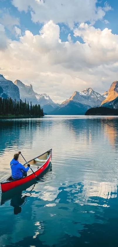 Canoeist paddling on a reflective mountain lake under a bright sky with distant peaks.