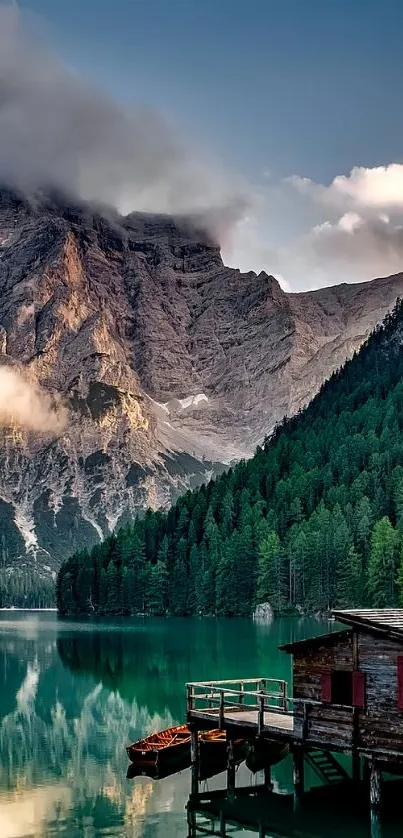 Serene mountain lake with cozy cabin and misty mountains.