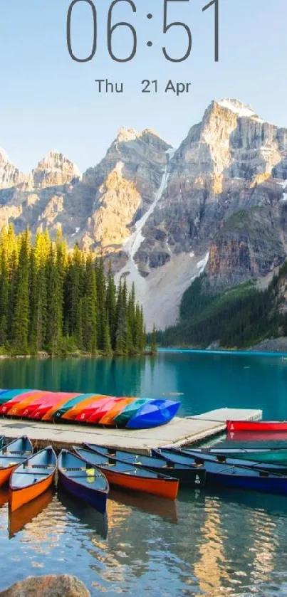 Vibrant canoes on a serene mountain lake with majestic peaks and clear blue skies.